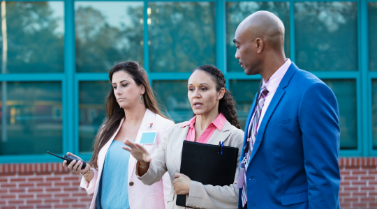 school-administrators-talking-outside-building